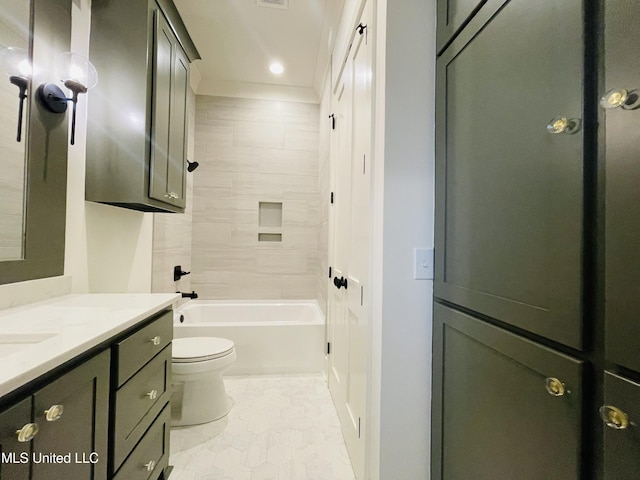 full bathroom featuring vanity, tiled shower / bath, and toilet