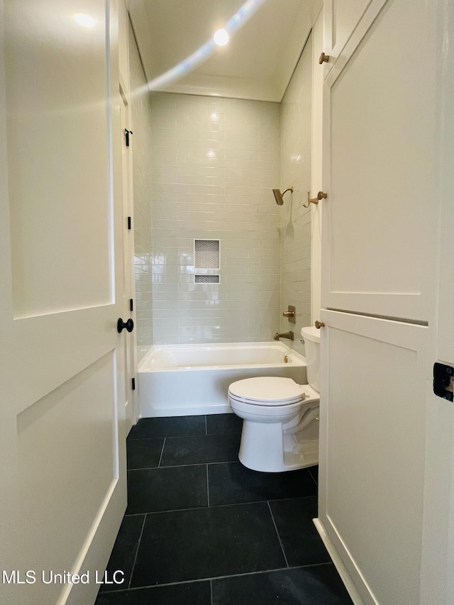 bathroom with tiled shower / bath, tile patterned floors, and toilet