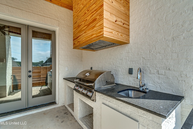 interior space with french doors, grilling area, an outdoor kitchen, and sink