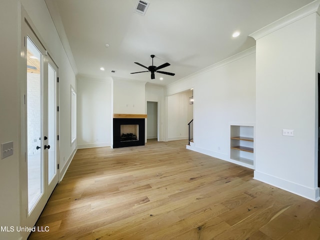 unfurnished living room featuring ceiling fan, ornamental molding, and light hardwood / wood-style flooring