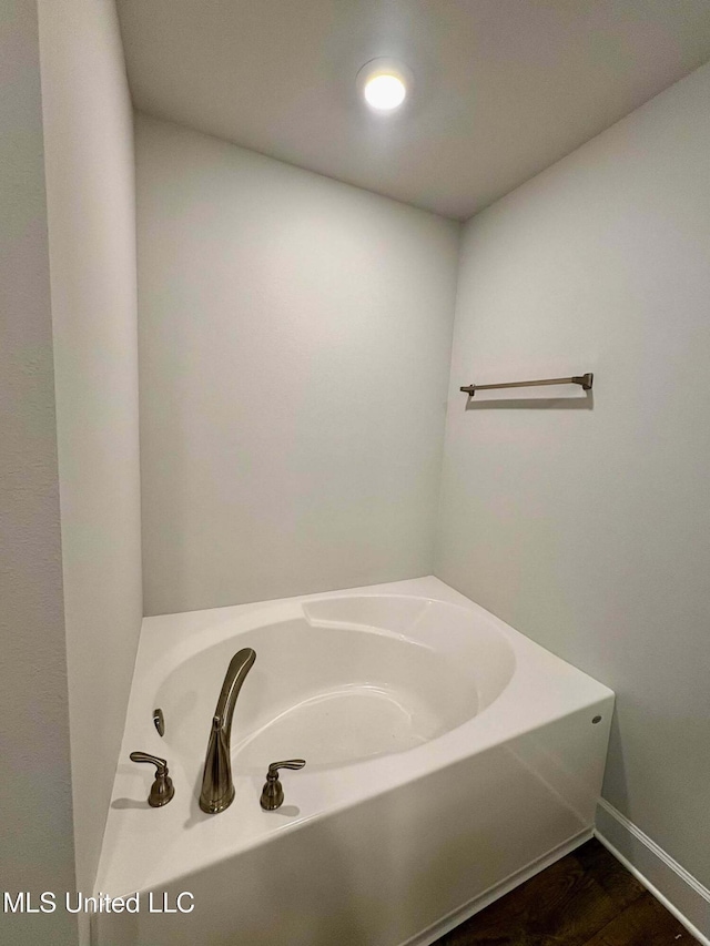 18085 Tiffany Renee Dr, Gulfport, MS 39503 - bathroom with a garden tub, baseboards, and wood finished floors
