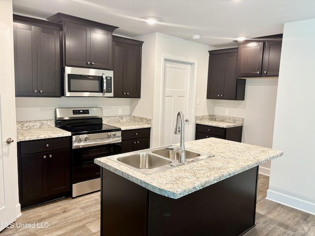 18085 Tiffany Renee Dr, Gulfport, MS 39503 - kitchen with a kitchen island with sink, light wood-type flooring, a sink, light countertops, and stainless steel appliances