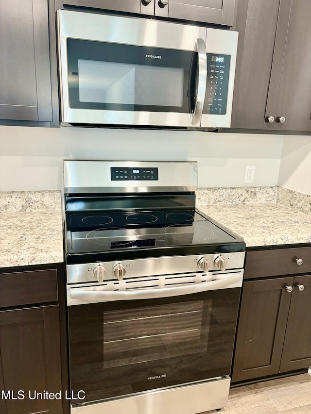 18085 Tiffany Renee Dr, Gulfport, MS 39503 - kitchen featuring light countertops, appliances with stainless steel finishes, dark brown cabinetry, and light wood-style floors
