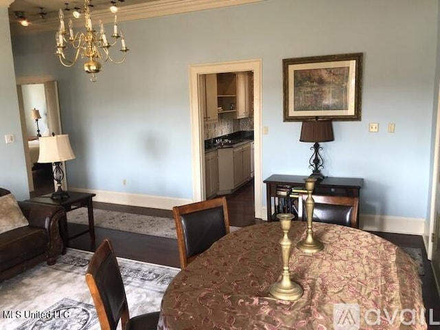 305 N Rankin St, Natchez, MS 39120 - dining space with crown molding, hardwood / wood-style flooring, and an inviting chandelier