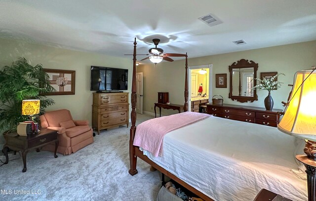 carpeted bedroom with ensuite bath and ceiling fan