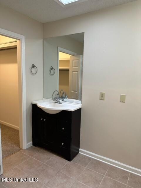 202 Kilford Ct, Madison, MS 39110 - bathroom with vanity, baseboards, tile patterned flooring, and a skylight