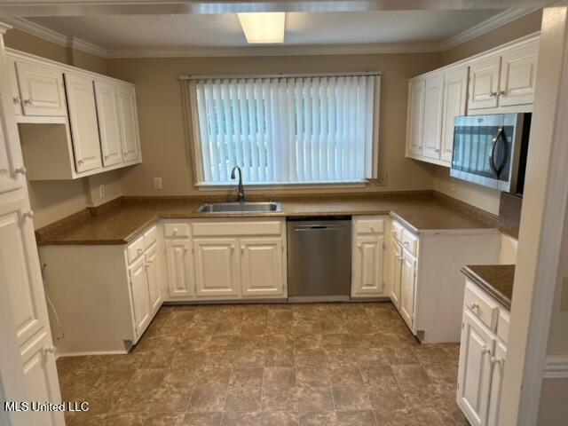 202 Kilford Ct, Madison, MS 39110 - kitchen with stainless steel appliances, a sink, ornamental molding, plenty of natural light, and dark countertops