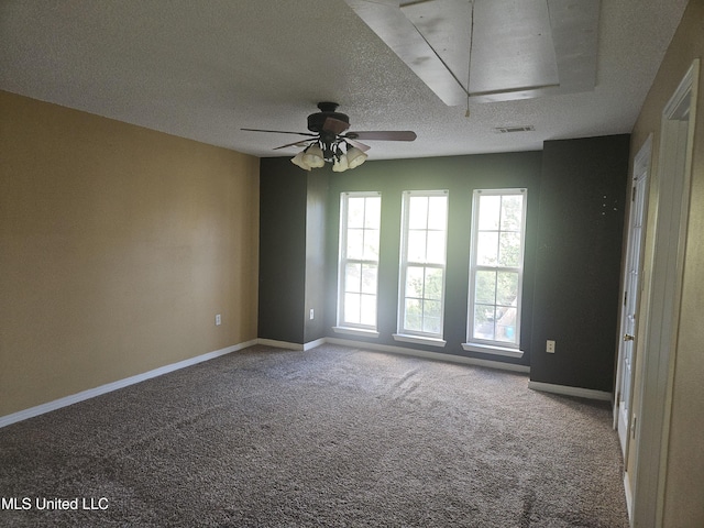 carpeted spare room with ceiling fan and a textured ceiling