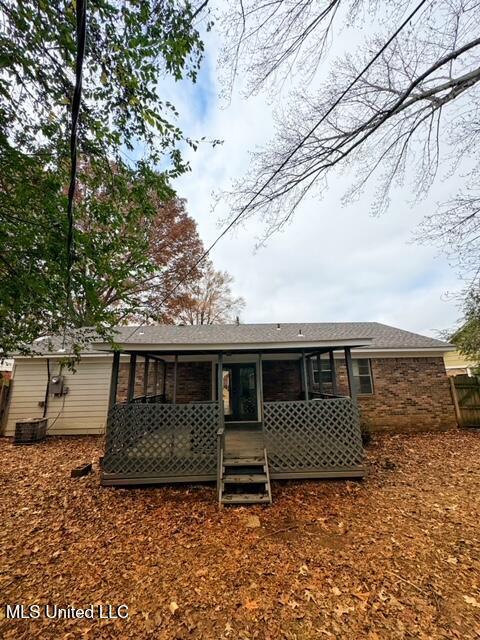 rear view of property featuring a sunroom