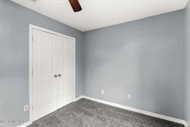 unfurnished bedroom featuring ceiling fan, dark carpet, and a closet