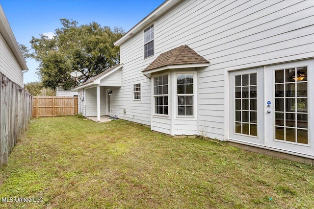 back of house featuring french doors and a lawn