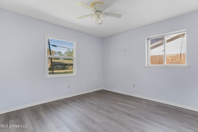 unfurnished room with hardwood / wood-style flooring, plenty of natural light, and ceiling fan