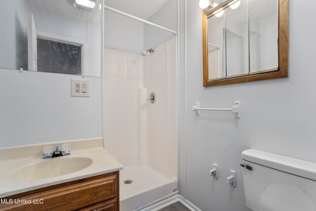 bathroom featuring vanity, a shower, and toilet