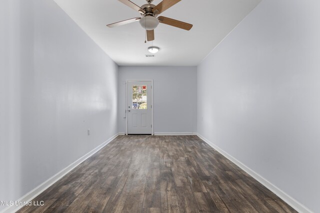 empty room with ceiling fan and dark hardwood / wood-style flooring