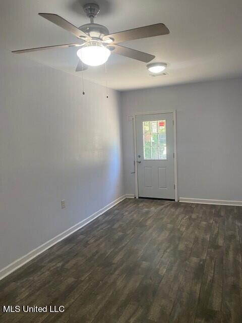 unfurnished room featuring ceiling fan and dark hardwood / wood-style flooring