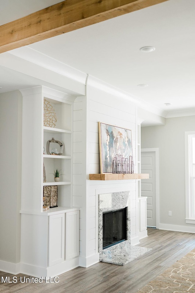 16043 W Dedeaux Rd, Gulfport, MS 39503 - unfurnished living room featuring wood finished floors, a high end fireplace, crown molding, and built in features