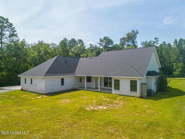 16043 W Dedeaux Rd, Gulfport, MS 39503 - back of house featuring a shingled roof, a yard, and a patio area
