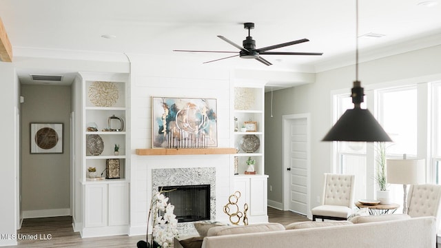 16043 W Dedeaux Rd, Gulfport, MS 39503 - living room featuring a ceiling fan, wood finished floors, a fireplace, ornamental molding, and built in shelves
