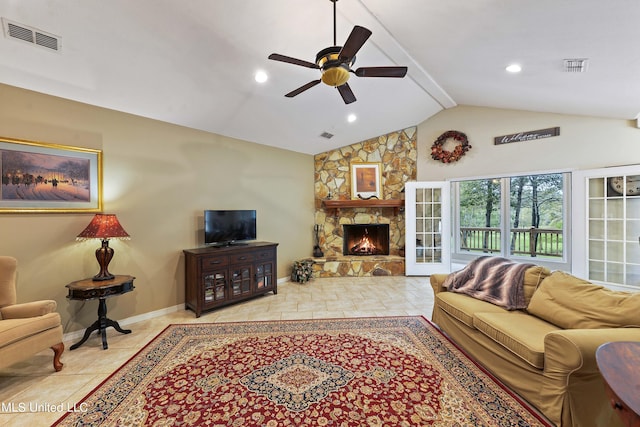 living room with ceiling fan, a stone fireplace, and lofted ceiling