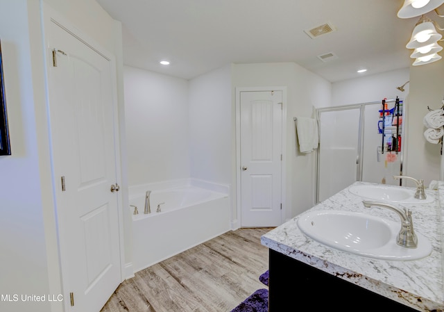 bathroom featuring vanity, wood-type flooring, and separate shower and tub