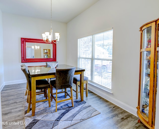 dining area featuring hardwood / wood-style floors and a notable chandelier