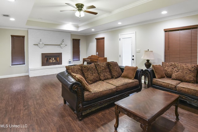 7520 Ogborn Dr, Moss Point, MS 39562 - living room featuring dark wood-style flooring, a raised ceiling, a ceiling fan, ornamental molding, and baseboards