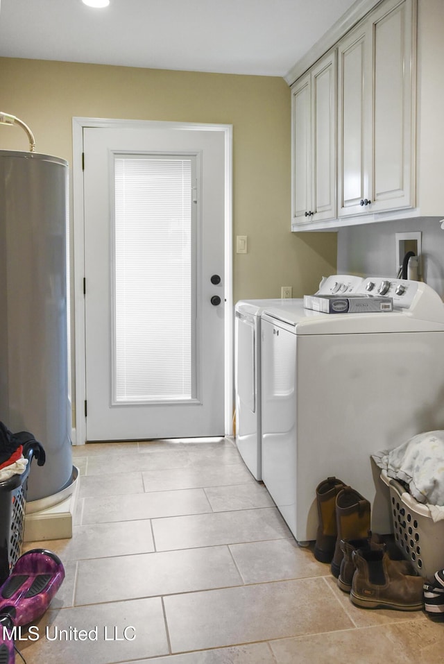 7520 Ogborn Dr, Moss Point, MS 39562 - washroom with water heater, washing machine and dryer, cabinet space, and light tile patterned flooring