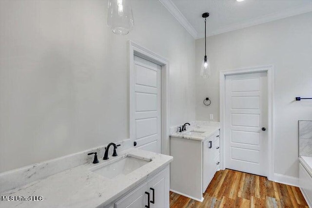 bathroom with wood-type flooring, vanity, a bathtub, and ornamental molding