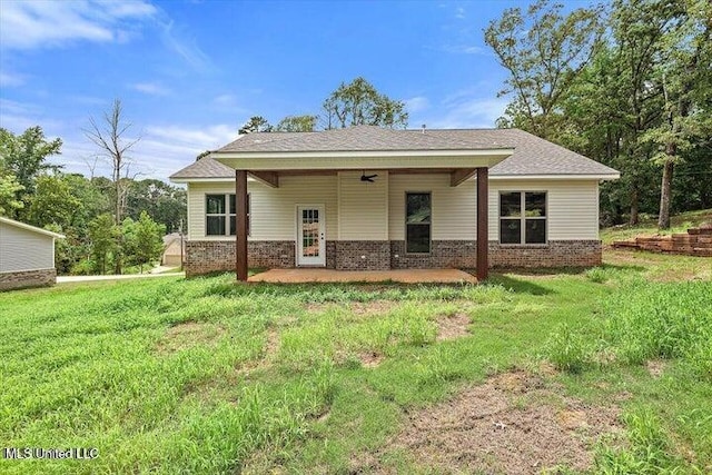 back of property with a patio, a yard, and ceiling fan