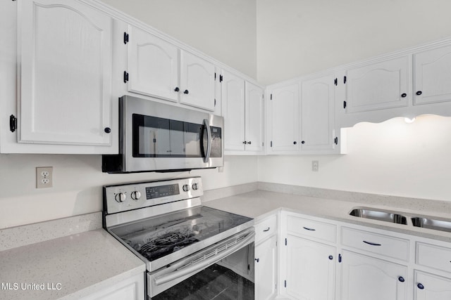 kitchen with white cabinetry, stainless steel appliances, and sink