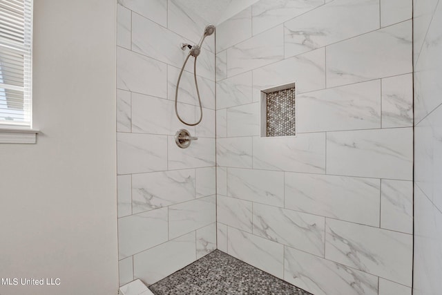 bathroom with a tile shower