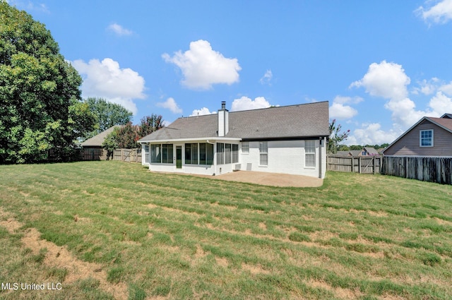 rear view of property with a sunroom and a lawn