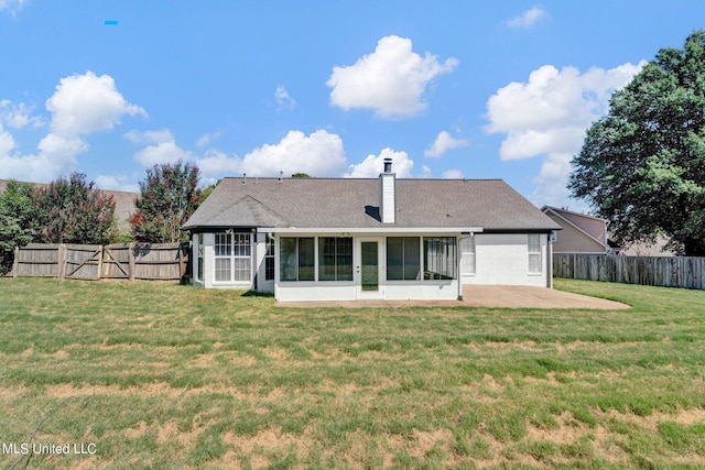 rear view of house featuring a patio, a lawn, and a sunroom