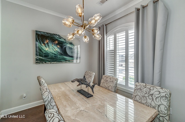 dining room featuring dark hardwood / wood-style flooring, ornamental molding, and an inviting chandelier