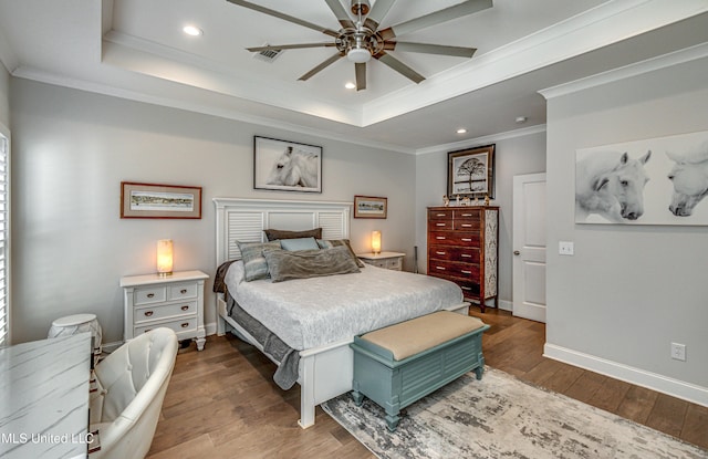 bedroom with a raised ceiling, ornamental molding, and dark wood-type flooring