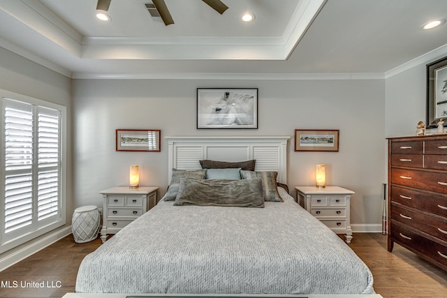 bedroom with a raised ceiling, ornamental molding, and dark hardwood / wood-style floors