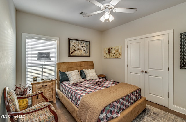 bedroom featuring ceiling fan, dark hardwood / wood-style floors, and a closet