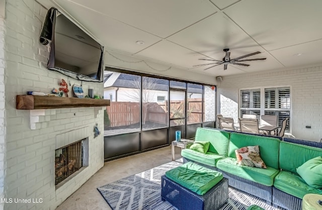 sunroom / solarium featuring ceiling fan and a fireplace