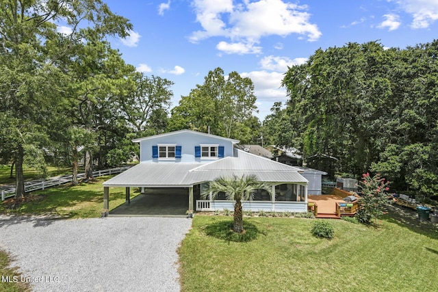 view of front of house with a carport, a deck, and a front yard