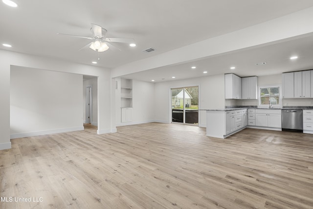 unfurnished living room featuring a healthy amount of sunlight, ceiling fan, and light hardwood / wood-style flooring