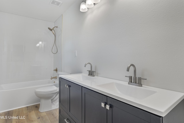 full bathroom with vanity, toilet, tiled shower / bath combo, and hardwood / wood-style floors