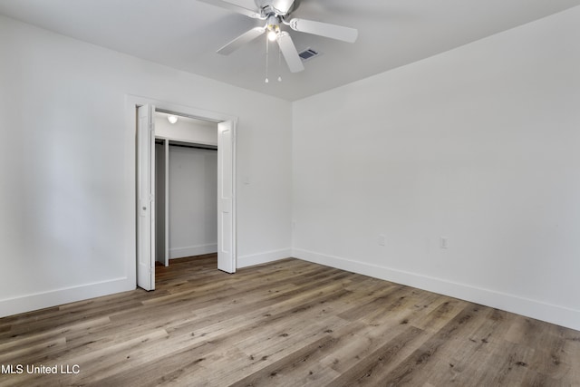 unfurnished bedroom featuring ceiling fan, a closet, and light wood-type flooring