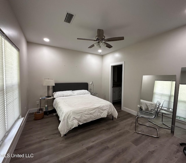 bedroom with visible vents, multiple windows, baseboards, and wood finished floors
