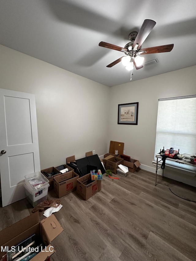 misc room with visible vents, baseboards, a ceiling fan, and wood finished floors