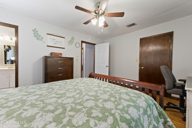 bedroom featuring ensuite bathroom, ceiling fan, wood-type flooring, and sink