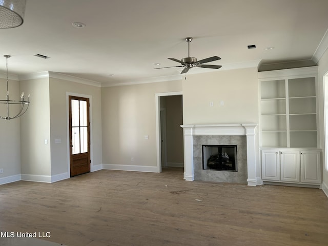 unfurnished living room featuring crown molding, wood finished floors, and a tile fireplace