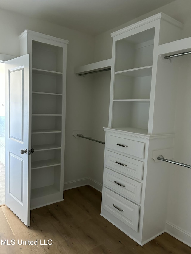 walk in closet with wood finished floors