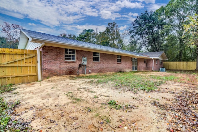 rear view of property with central AC