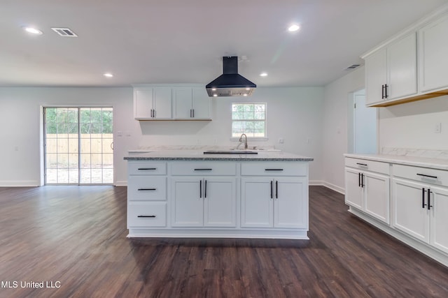 kitchen featuring dark hardwood / wood-style floors, light stone counters, white cabinetry, and island exhaust hood