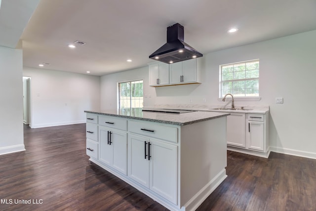 kitchen with island exhaust hood, a center island, white cabinetry, and sink